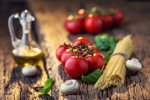 Spaghetti.Spaghetti tomatoes basil olive oil parmesan cheese and mushrooms on very old oak board. Mediterrannean cuisine and ingredients photo