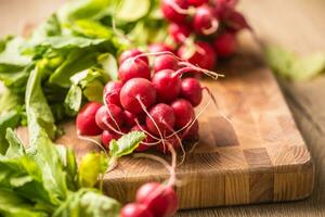 Fresh bundles of radish laid on a kitchen table photo