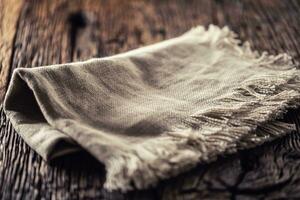 Flax or jute rustical rag folded on dark wooden table photo
