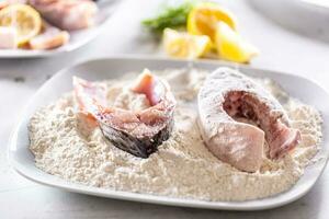 Preparation of fresh fish before frying by wrapping in flour photo