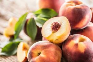 A group a ripe peaches on wooden table photo