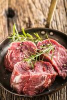 Close-up slices of beef tenterloin steak salt pepper and rosemary photo