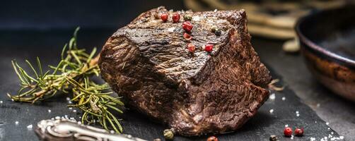 Juicy beef steak with spices and herbs on cutting board photo
