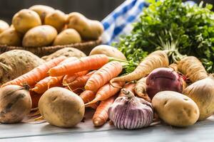 Assortment of fresh vegetables on wooden table. Carrot parsnip garlic celery onion and kohlrabi photo