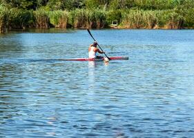 Technique of rowing of a single athlete on a kayak. Paddle splash motion. photo