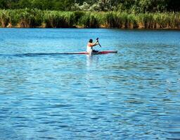 Technique of rowing of a single athlete on a kayak. Paddle splash motion. photo