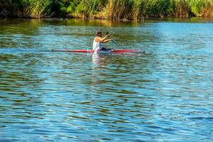 Technique of rowing of a single athlete on a kayak. Paddle splash motion. photo