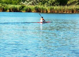 Technique of rowing of a single athlete on a kayak. Paddle splash motion. photo