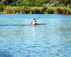 Technique of rowing of a single athlete on a kayak. Paddle splash motion. photo