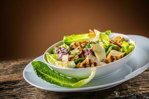 Delicious salad caesar with grilled chicken breast croutons eggs bacon parmesan cheese and  lettuce with dressing photo