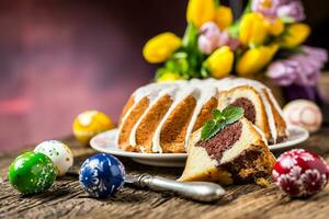 Easter Cake. Traditional ring marble cake withe easter decotation. Easter eggs and spring tulips. photo