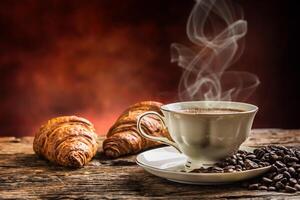 café. taza de café croissants y café frijoles. Clásico taza y antiguo roble mesa foto