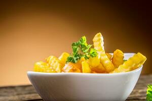 Potato fries in white bowl with parsley herb photo