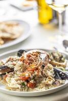 Detail of a seafood risotto made the Italian way and served on a shallow plate photo