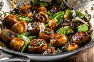 Roasted mushrooms in a wok with spring peas, onion and teriyaky sauce photo