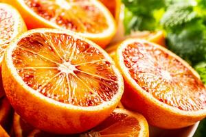 Blood sicilian oranges sliced with fresh melissa - close up photo