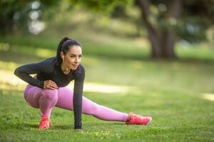 Young woman runner warming up before running. photo