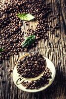 Top of view cup full of coffee beans on rustic oak table photo