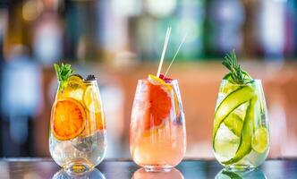 Tree colorful gin tonic cocktails in glasses on bar counter in pup or restaurant. photo