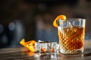 Old fashioned rum drink on ice with orange zest garnish photo