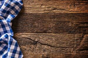 Blue checkered kitchen tablecloth on rustic wooden table photo