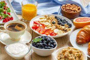Healthy breakfast served with plate of yogurt muesli blueberries strawberries and banana. photo