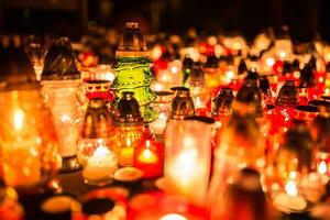 muchos ardiente velas en el cementerio a noche en el ocasión almas de el fallecido foto