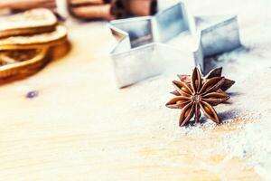 Star anise cookie cutter cinnamon and flour on baking board. Christmas baking utensil and holiday concept photo