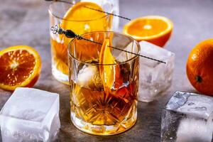 Glasses of cocktail drinks Old fashioned with oranges and ice cubes photo