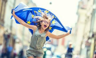 linda contento joven niña con el bandera de el europeo Unión foto