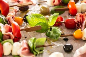 Caprese skewers italian or mediterranean appettizer tomatoes mozzarella olives and prosciutto photo