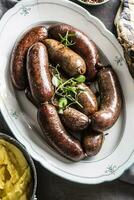 Roasted sausages in pan with rosemary. Traditional european food bratwurst jaternice or jitrnice photo