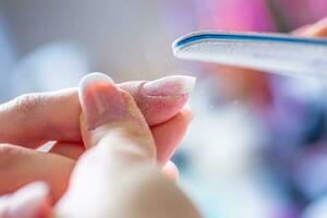 Close-up manicure of female nails in nail salon photo