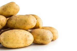 A pile washed potatoes isolated on white. photo