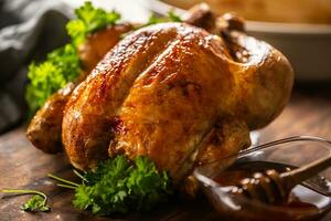 Whole baked chicken with crusty skin glazed with honey on top and parsley on the side photo