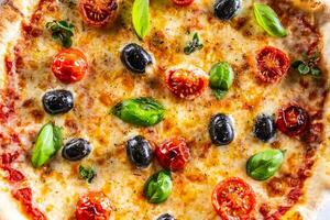 Structure pizza with tomatoes mozzarella cheese olives and basil - top pof view photo