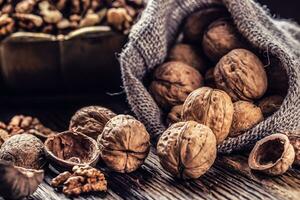 Walnut kernels whole walnuts in burlap sack and vintage bowl photo