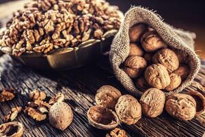 Walnut kernels whole walnuts in burlap sack and vintage bowl photo