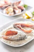 Preparation of fresh fish before frying by wrapping in flour photo