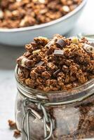 Jar of muesli with dark and milk cocolate pieces - closeup photo