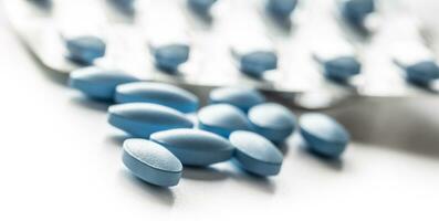 Blue pills loose lying on a white isolated background photo