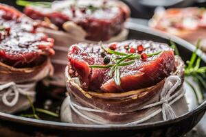 Beef tenderloin steak wrapped in bacon stored into the pan photo