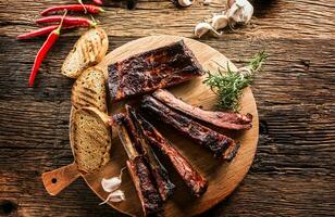 Tasty barbecue grilled pork ribs with chili pepers and parsley herbs. photo