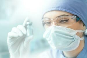 Female laboratory technician with ampoule of virus vaccine photo