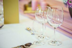 Wedding table setting. Beautiful table set with flowers and glass cups  for some festive event, party or wedding reception photo