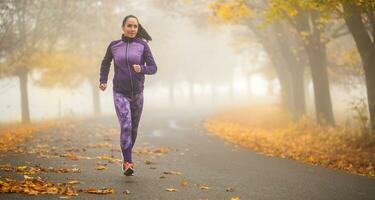 deportivo mujer corriendo en brumoso otoño naturaleza foto