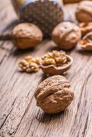 Walnut. Walnut kernels and whole walnuts on rustic old oak table photo