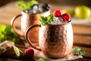 Moscow Berry Mule highball vodka cocktail is a long drink with fresh lime juice, ginger beer and berries photo