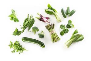 Assorment of fresh green vegetables isolated on white background photo