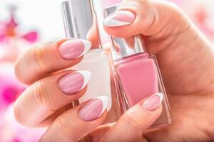 Trendy nail manicure. Woman hands holding nails polishes photo